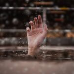 Wyciągnięta ręka z wody szukająca pomocy
