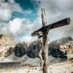 Drewniany krzyż z figurką Pana Jezusa na tle gór