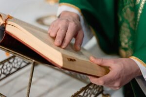 Dłonie księdza na biblii sprawującego Msze Święte