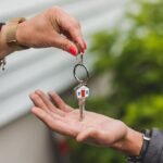 Kobieta przekazująca klucze od domu mężczyźnie po sprzedaży i kupnie mieszkania