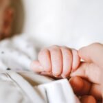 Noworodek, dziecko trzymające mamę za palec