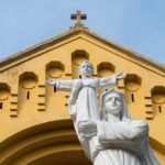 Figura Matki Bożej z Jezusem na tle kościoła