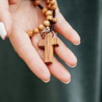Drewniany różaniec w rękach modlącej się kobiety