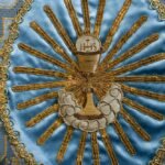 Płócienny sztandar z wyhaftowaną hostią