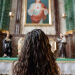 Kobieta modląca się w kościele przed obrazem Jezusa Miłosiernego