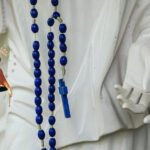 Niebieski różaniec wiszący na figurze