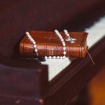 Biblia i biały różaniec na fortepianie
