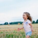 Mała dziewczynka biegająca po łące