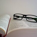 Okulary do czytania leżące na otwartej książce