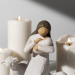 Drewniana figurka Matki Bożej z dzieckiem. Świeczki i owca