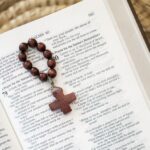 Drewniana dziesiątka różańca leżąca na biblii