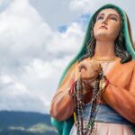 Figura Matki Bożej z różańcami na rękach