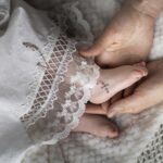 Stopy małego dziecka z różańcem