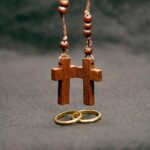 Dwa krzyżyki od różańca i obrączki małżeńskie