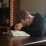 Mężczyzna modlący się przy biblii