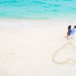 Para zakochanych na plaży i serce na piasku