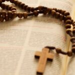 Drewniany różaniec leżący na biblii