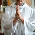 Ksiądz w kościele z różańcem na rękach