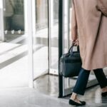 Kobieta z torebką wchodząca do biura, pracy