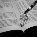 Różaniec z krzyżem Ducha Świętego leżący na biblii