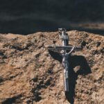Metalowy krzyż leżący na kamieniu
