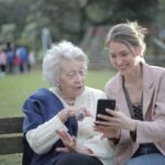 Babcia z wnuczką siedząca na ławce w parku