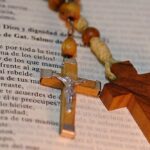 Drewniane krzyże różańca leżące na biblii