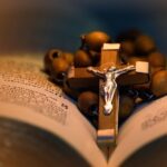 Drewniany różaniec z krzyżem leżący na biblii