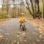 Mały chłopiec jadący na rowerze w parku