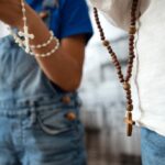 Ludzie trzymający w rękach różańce