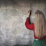 Kobieta pisząca na tablicy podczas egzaminu