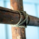 Drewniany krzyż opleciony sznurkiem