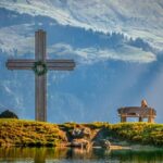 Krzyż w górach, kobieta siedząca na ławce