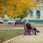 Starszy mężczyzna siedzący na ławce w parku