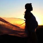 Kobieta w ciąży na tle zachodu słońca